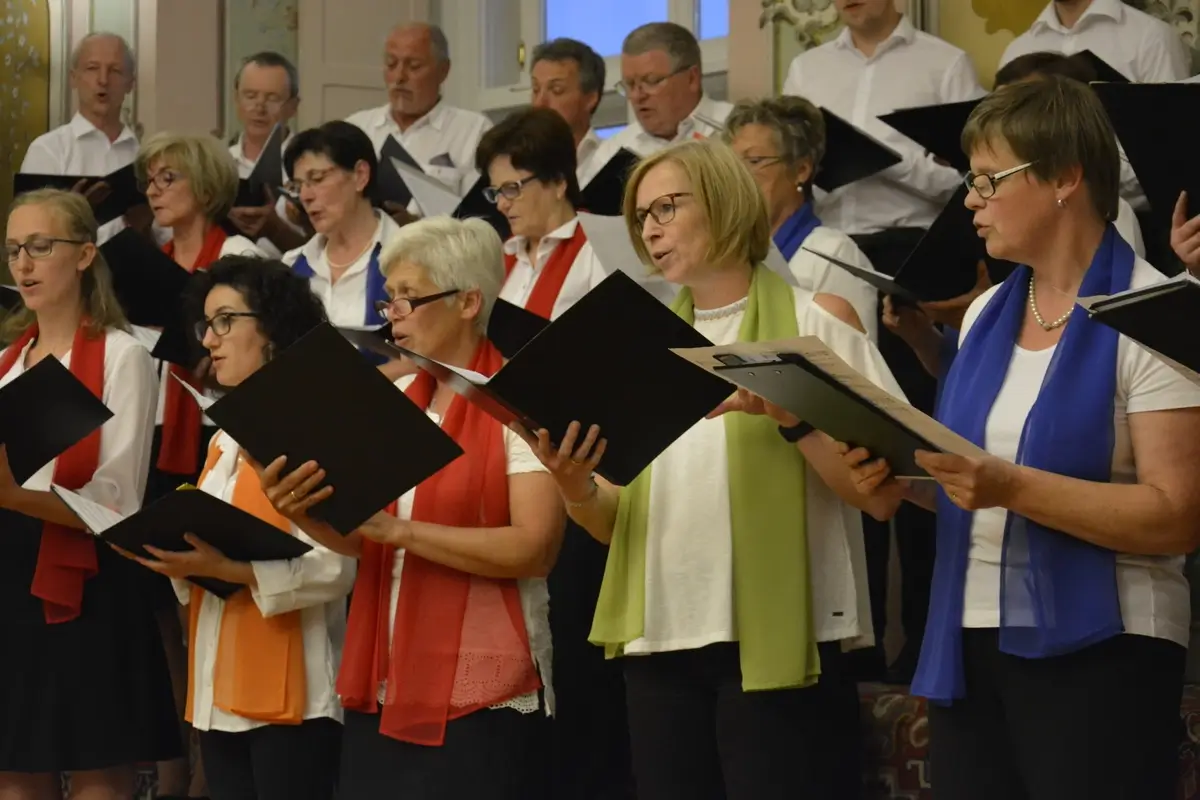 The Vorau Choir singing and holding the music notes, the concert in the Baroque Hall of Vorau Abbey 2017.